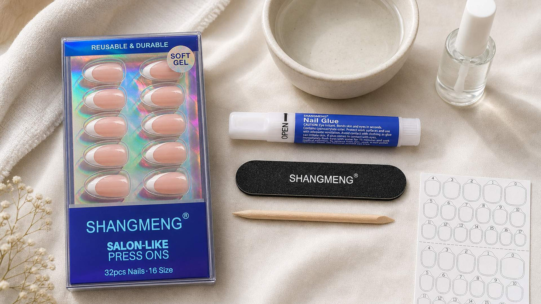 Real SHANGMENG press-on nail kit flat lay for avoiding common mistakes, with the authentic product box, glue, nail file, cuticle stick, adhesive tabs, warm-water removal bowl, and cuticle oil on a neutral surface, no hands and no extra readable text