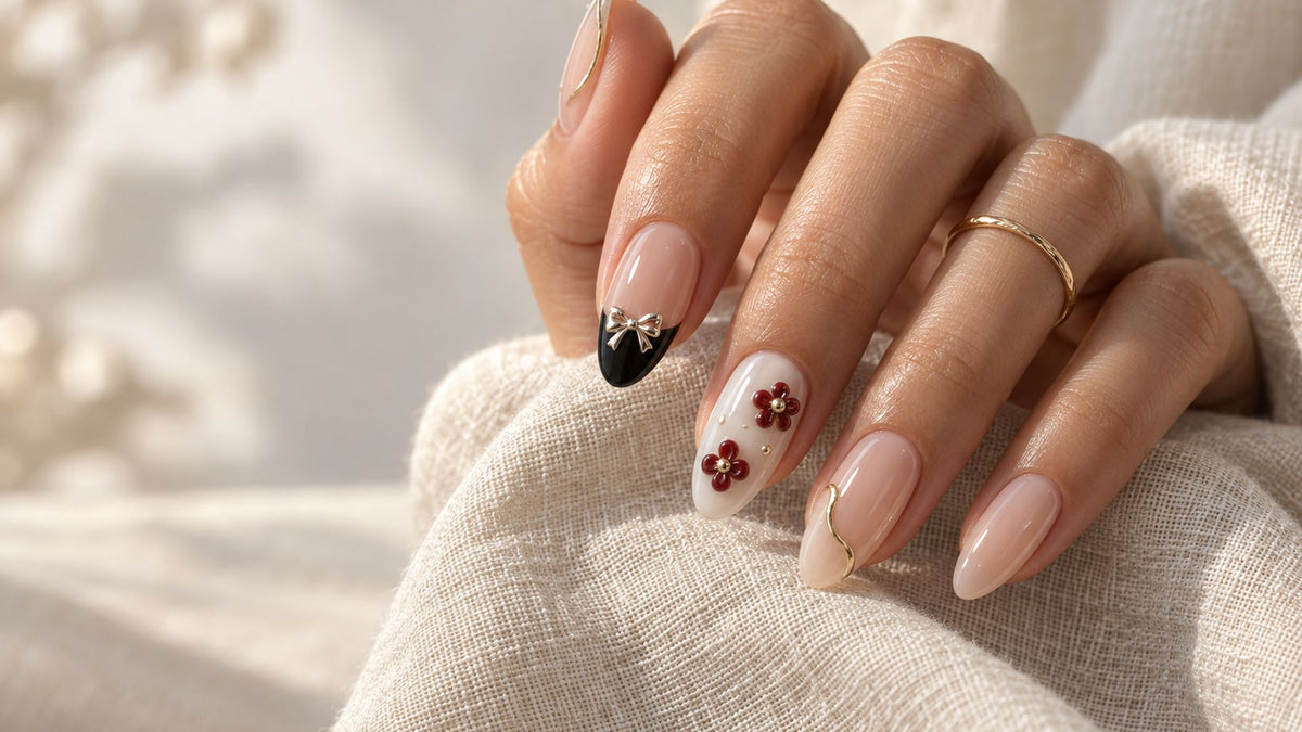 3D nail art press-on nails with raised bows, flowers and gold lines on an almond-shaped manicure