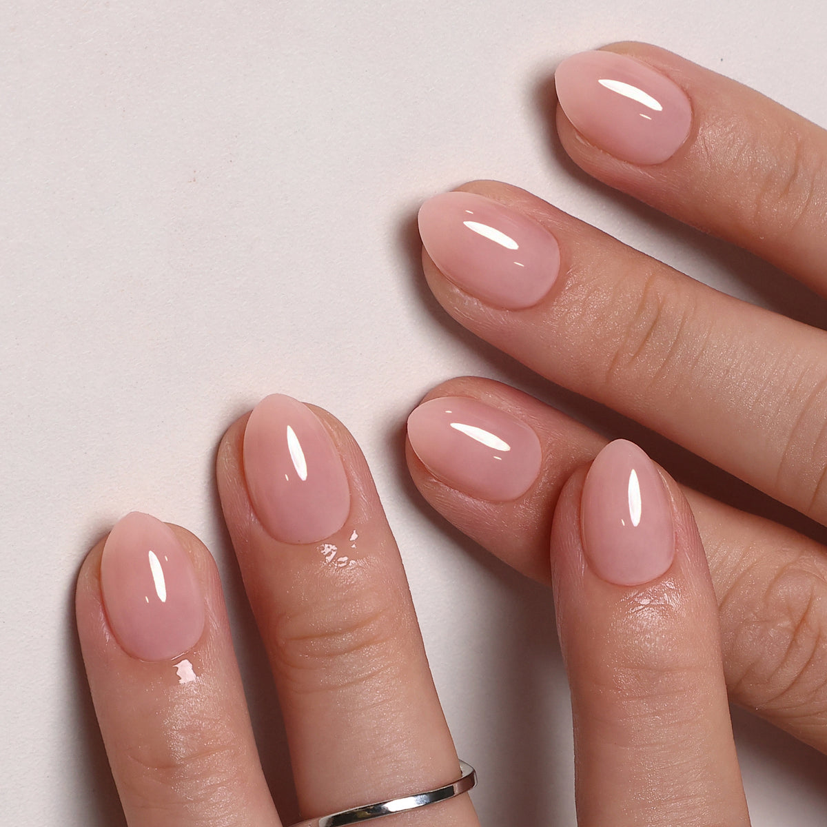 Soft Whisper Nude unhas press-on amendoadas extra curtas: vista angulada da mão em luz natural | SHANGMENG®