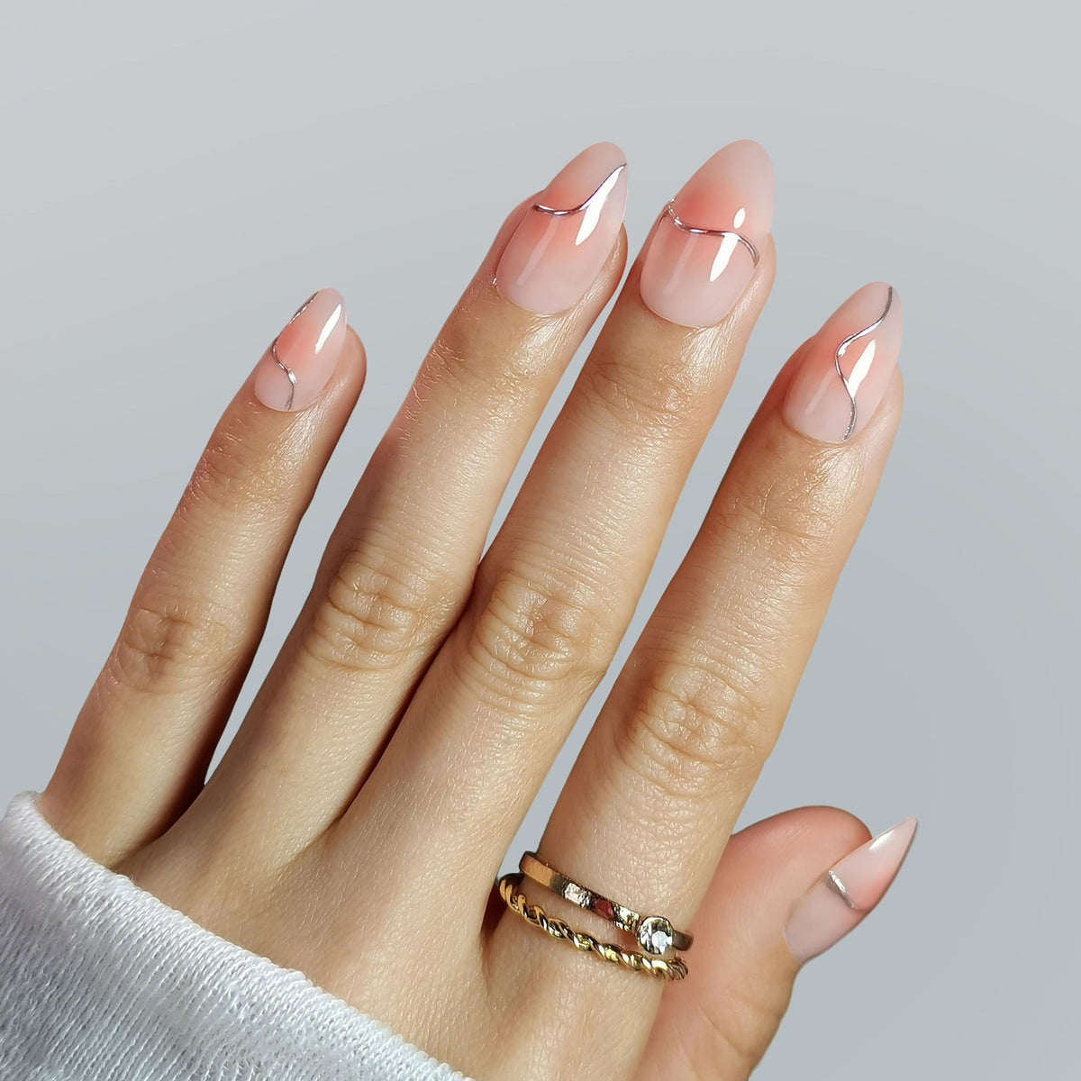 Silver futuristic ombre pink 3D almond press-on nails worn on hand